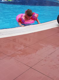 High angle view of girl sitting on swimming pool