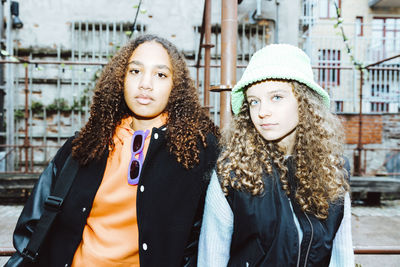 Portrait of female friends with curly hair spending leisure time together