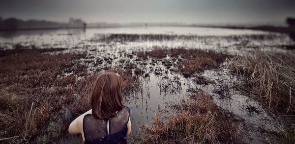 Rear view of girl looking at marshland