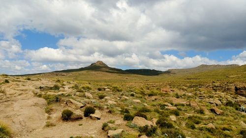 Scenic view of green landscape against cloudy sky