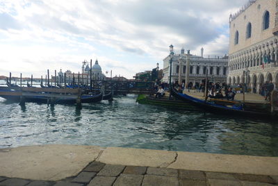 Boats in canal amidst buildings in city