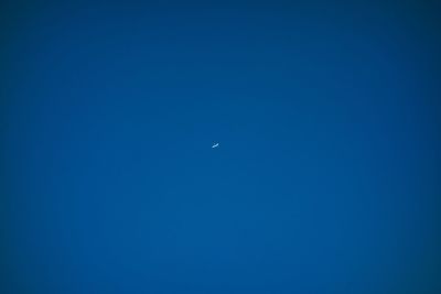 Low angle view of moon against clear blue sky