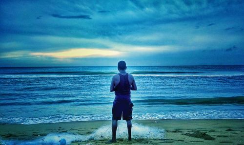Rear view of man standing on beach