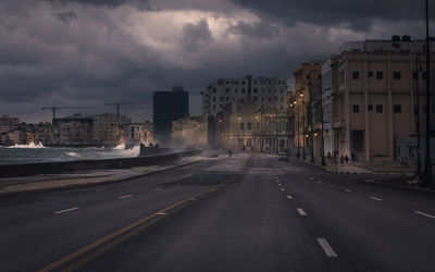 Road amidst buildings against sky in city