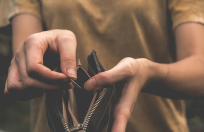 Midsection of woman holding purse and coin