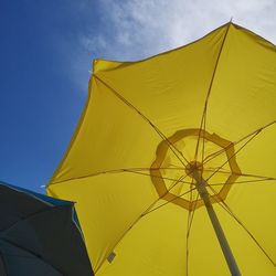 Low angle view of yellow umbrella against sky