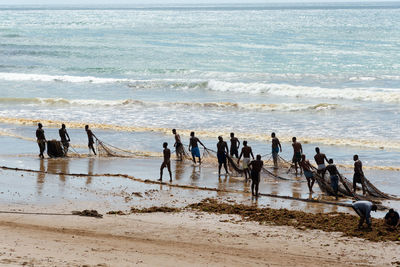 Fishermen unrolling the large fishing net for fishing on boca do rio beach