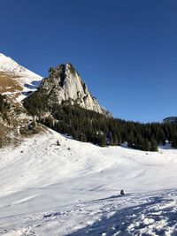 Scenic view of snowcapped mountains against clear blue sky