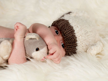 Midsection of baby lying on bed