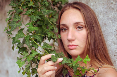 Portrait of young woman holding plant