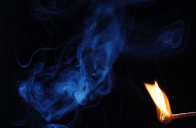 Close-up of lit matchstick against black background