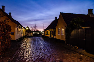 Street amidst buildings in city at night