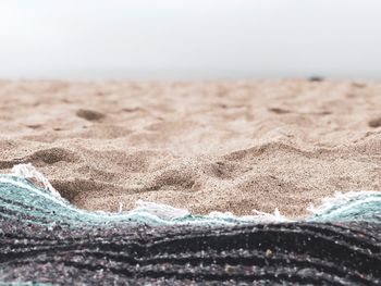 Close-up of sand on beach against clear sky