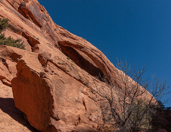 Full frame low angle view of a sandstone arch against a clear blue sky