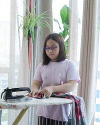 Girl pressing clothes at home