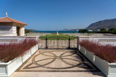 Built structure by sea against clear blue sky