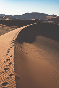 Sand dunes in desert against sky