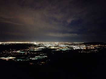 Aerial view of illuminated cityscape against sky at night