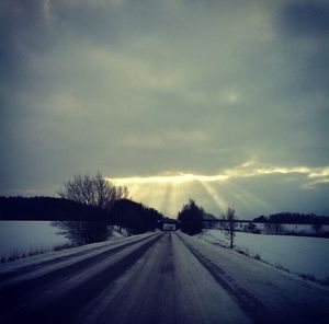 View of road against cloudy sky at sunset