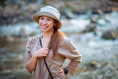 Portrait of smiling young woman standing outdoors