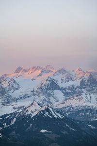 Scenic view of snowcapped mountains against sky during sunset