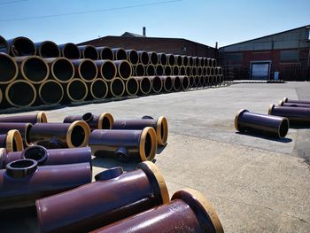 Stack of pipes against sky on sunny day