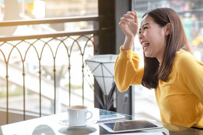Young woman with coffee cup on table
