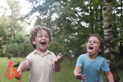 Boy playing with bubbles at park