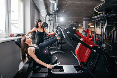 Rear view of man using mobile phone in gym