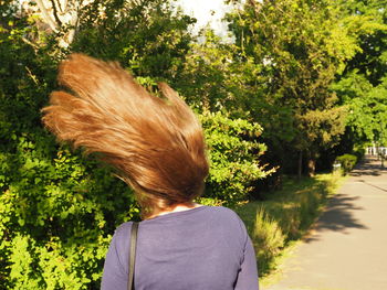 Rear view of woman with tossing hair in park