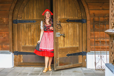 Full length of young woman standing against wall