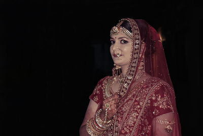 Woman looking away against black background