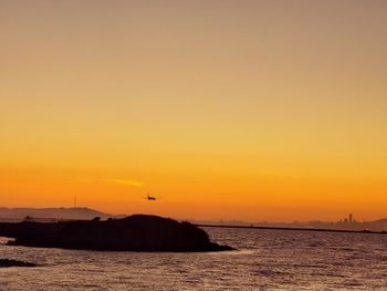 Scenic view of sea against orange sky