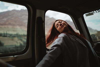 Mid adult man looking through car window