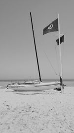 Sailboat on beach against clear sky