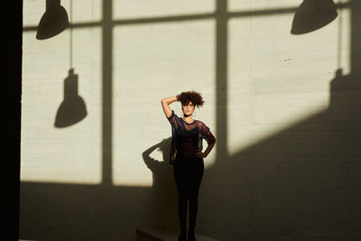 Young woman standing against wall