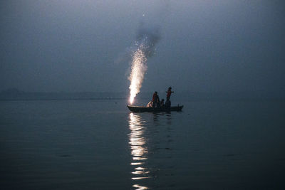 People sailing on sea against sky