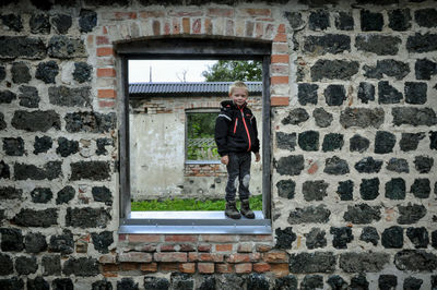 Man standing against brick wall