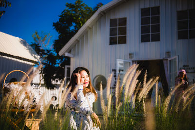 Full length of woman standing in yard against building