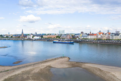 Scenic view of river by buildings against sky