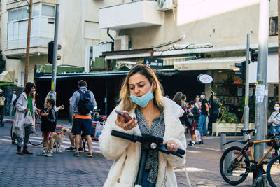 Portrait of woman with umbrella on street in city