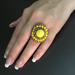 Close-up of woman hand holding ring over black background