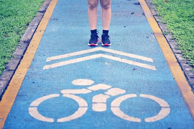 Low section of woman standing on footpath