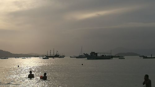 Sailboats in sea against sky