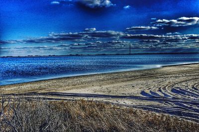 Scenic view of beach against cloudy sky