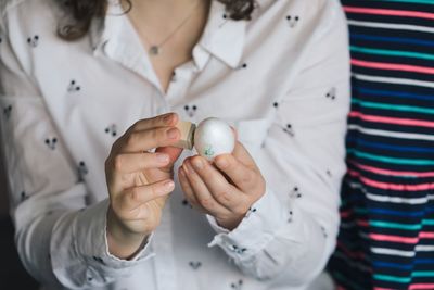 Midsection of woman decorating easter egg