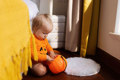 Cute baby playing with pumpkin at home