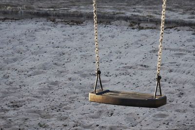 Close-up of swing on sand