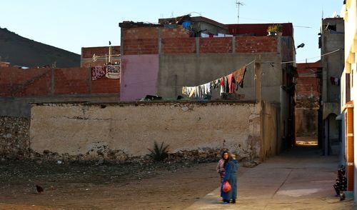 Full length of woman on clothesline against building