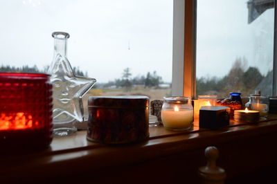 Close-up of wine glasses on table against window